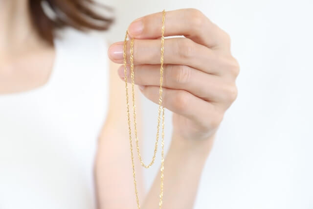 金色チェーンを持つ手元のクローズアップ